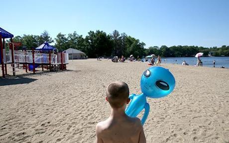 Connor Biscan, 12, walks the beach at Silver Lake in Wilmington with his alien balloon while visiting with his family.
