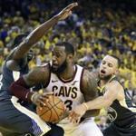 LeBron James has little room to work when surrounded by Draymond Green (left) and Stephen Curry during the second half of Game 2.