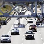 Cars pass under toll sensor gantries hanging over the Massachusetts Turnpike, Monday, Aug. 22, 2016, in Newton, Mass. The state Department of Transportation is discussing plans for demolishing the tollbooths as it gets ready to implement an all-electronic tolling system on Interstate 90 which runs the length of the state. (AP Photo/Elise Amendola)