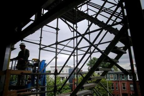 Boston, MA - 06/06/18 - Scaffolding frames a worker on the exterior of the new building. Boston Collegiate Charter School is expanding with new construction. Although charter schools must raise capital for construction projects privately, a building boom is occurring throughout the city among such schools. (Lane Turner/Globe Staff) Reporter: (James Vaznis) Topic: (08charterschools)
