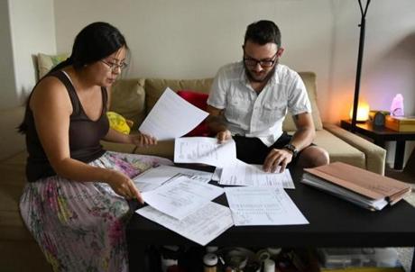 06/07/2018 LITTLETON, CO- Gunnar Vincens, right, and his wife Zhongmei Vincens have been fighting their former rental apartment, the Water's Edge Apartments in Revere, MA , since last August to receive their security deposit back. They moved out on August 14, 2017 and now live in Littleton, Colorado where they were photographed at their home on Thursday, June 7, 2018. They looked for documents in a folder filled with paperwork from their legal battle for their $1700 security deposit as they describe the ordeal. (Photo Cyrus McCrimmon for The Boston Globe)
