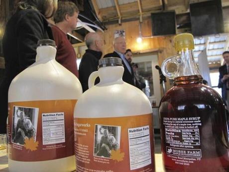 Containers of maple syrup, with nutrition facts on their labels are lined up on a table at Morse Farm Sugarworks in East Montpelier, Vt., Tuesday, May, 1, 2018. Maple syrup and honey producers aren't too sweet on a plan to label their natural products as containing added sugars. The FDA plans to require updated nutrition labels for products that would say that pure maple syrup and honey contain added sugars. (AP Photo/Lisa Rathke)
