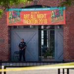 A Police officer stands in front as other officers inspect the crime scene at the Roebling Market on June 17, 2018, the morning after a shooting at an all-night art festival injured 20 people and left one suspect dead in Trenton, New Jersey. / AFP PHOTO / DOMINICK REUTERDOMINICK REUTER/AFP/Getty Images