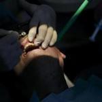 ADVANCE FOR USE SUNDAY, APRIL 15 - In this Tuesday, April 3, 2018 photo, Dr/ Robert Pellerin works on polishing and contouring the teeth of a patient at his dental office in Virginia Beach. Va. Pellerin has been a dentist for 40 years and was diagnosed with idiopathic pulmonary fibrosis four years ago. Pellerin believes that early exposure to toxic materials prior to the use of protective face masks could be the cause of his disease and he shared his theory with the Centers for Disease Control and Prevention. (Kristen Zeis/The Virginian-Pilot via AP)