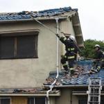 Firefighters check a house damaged by an earthquake in Ibaraki City, north of Osaka prefecture on June 18, 2018. A strong quake hit western Japan early June 18, but there were no immediate reports of major damage or risk of tsunami waves, officials said. / AFP PHOTO / JIJI PRESS / STR / Japan OUTSTR/AFP/Getty Images