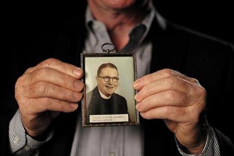 Jim Graham with a picture of the Rev. Thomas Sullivan, who he contends was his father.  Suzanne Kreiter/Globe staff)
