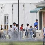Immigrant children walk in a line outside the Homestead Temporary Shelter for Unaccompanied Children a former Job Corps site that now houses them, on Wednesday, June 20, 2018, in Homestead, Fla. U.S. Rep. Carlos Curbelo said he found it 