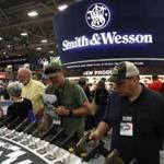 Attendees looked at a display of Smith and Wesson handguns during the NRA Annual Meeting & Exhibits at the Kay Bailey Hutchison Convention Center in Dallas.