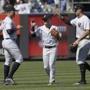 New York Yankees left fielder Giancarlo Stanton, left, center fielder Clint Frazier and right fielder Aaron Judge, right, celebrate after the Yankees defeated the Seattle Mariners 4-3 in a baseball game Thursday, June 21, 2018, at Yankee Stadium in New York. (AP Photo/Bill Kostroun)