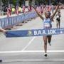 Boston, MA - 6/24/2018 - Mary Wacera or Kenya raises her hands as she crosses the finish line to win the women's segment of the BAA 10K race in Boston, MA, June 24, 2018. (Keith Bedford/Globe Staff)
