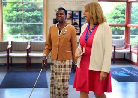 Margaret Baba Diri walked in the lobby of the Carroll Center for the Blind in Newton with Dina Rosenbaum (right), chief program officer for the center.

