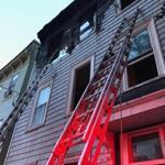 Fire crews used a ladder to reach the top floor of a home on Mercer Street in South Boston.