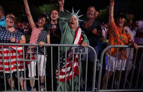 Dressed as Lady Liberty, Carol Hunt, of Milton, sings along during the Boston Pops Fireworks Spectacular at the Hatch Shell on the Esplanade.
