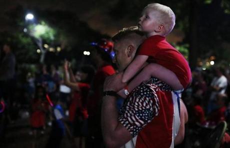 BOSTON, MA - 07/04/2018 Bradley Skidmore watches the fireworks with his nephew Eli, two-years-old, after the Boston Pops Fireworks Spectacular. Despite the heat; 