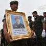 A Royal Thai Navy soldier carried a portrait of Saman Gunan, a former navy SEAL who died duirng a rescue mission for the trapped 12 boys and their coach, during arrival honors for Gunan's remains at a military base in Chon Buri province on Friday.