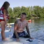 Rome, ME--6/26/2018-- Brandon Long, a Marine who lost both of his legs while serving in Afghanistan looks back at his daughter, Claire, 7, right before she pushes him into Long Pond as the two play by the waterfront at the Travis Mills Retreat. (Jessica Rinaldi/Globe Staff) Topic: 01maine Reporter: Brian MacQuarrie