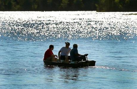 Men sat in a boat on West Lake of Monponsett Pond in Hanson. A kayaker was pulled out Saturday.
