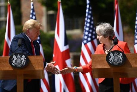 Britain's Prime Minister Theresa May (L) welcomes US President Donald Trump on his arrival for a meeting at Chequers, the prime minister's country residence, near Ellesborough, northwest of London on July 13, 2018 on the second day of Trump's UK visit. US President Donald Trump launched an extraordinary attack on Prime Minister Theresa May's Brexit strategy, plunging the transatlantic 
