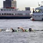 Nearly 70 swimmers, including seven Olympians, sliced through the waters of Boston Harbor on Friday, ?making waves? in the fight against cancer for the 22nd annual Swim Across America event, officials said.