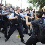 Members of the Chicago police department scuffle with an angry crowd at the scene of a police involved shooting in Chicago on Saturday.