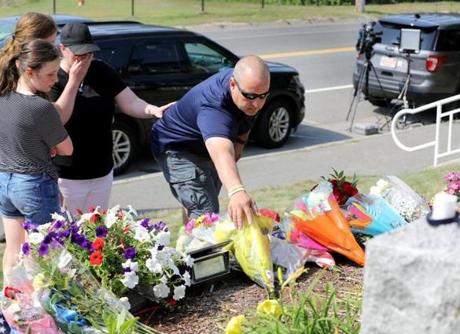 Barnstable Police Officer Dennis Stampfl (center) and his wife Melissa, and their two daughters Alexandra and Michaela, left flowers in the front of the Weymouth Police station on Monday.
