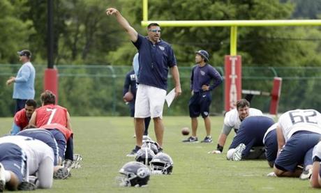 In this June 13, 2018 photo, Tennessee Titans head coach Mike Vrabel, center, watches as players warm up during NFL football minicamp in Nashville, Tenn. The Titans wrap up their first offseason under their new coach with the end of a three-day minicamp. Now they're off until the end of July and training camp. (AP Photo/Mark Humphrey)
