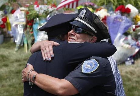  Weymouth police officers embraced after the procession for slain officer Michael Chesna passed by the police statio.
