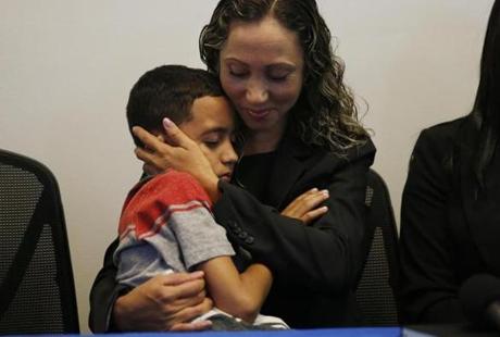 Allston, MA--7/16/2018-- An Immigrant mother who has asked to be identified by the initials W.R. cradles her 9 year-old son, A.R. during a press conference at the Brazilian Worker Center. (Jessica Rinaldi/Globe Staff) Topic: 17reunionpic Reporter: 
