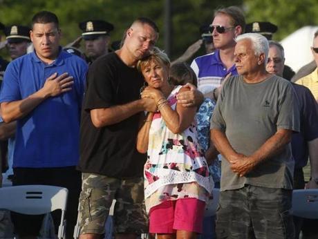 Members of Weymouth police officer Michael Chesna's family embraced at a candlelight vigil held in his honor. 
