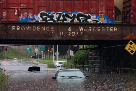 Two flooded out vehicles sit under the railroad bridge on Cambridge Street in Worcester, Massachusetts on July 17, 2018. Heavy rain caused flash flooding in many parts of the region. Photo by Matthew Healey
