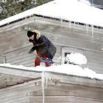 A man shoveled snow off his roof in Concord on March 14.