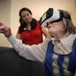 Anna Lisa Gotschlich, who lives with dementia, exclaimed about what she could see as she used virtual reality to take a virtual trip to her childhood hometown in Sweden. Delmy Flagg, Memory Care Director at Maplewood, listens.