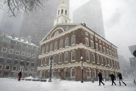 FILE - In a Tuesday, March 14, 2017 file photo, people walk past Faneuil Hall during a winter storm, in Boston. Officials say the 275-year-old building will close starting Monday, Jan. 1, 2018, for renovations that include upgraded elevator services and improved heating and cooling. (AP Photo/Michael Dwyer, File)
