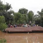 Villagers take refuge on a rooftop after water from a collapsed dam flooded the area in Laos. 