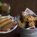 Fried chicken served in a bucket with cornbread, butter, and a mint julep at the Frogmore. 