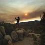Mara Schumann photographs a plume of smoke from the Ferguson Fire in Yosemite National Park, Calif., on Tuesday, July 24, 2018. Parts of the park, including Yosemite Valley, will close Wednesday as firefighters work to stop the blaze. (AP Photo/Noah Berger)