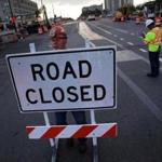 Bill Gailes of Liddell Brothers placed a road closure sign on Commonwealth Avenue Thursday.  