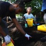 Amiah Wilson, age 4, helped fill up a bucket of dirt at the Common Good co-op farm.