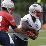 New England Patriots quarterback Tom Brady, left, hands off to rookie running back Sony Michel, right, during an NFL football minicamp practice, Tuesday, June 5, 2018, in Foxborough, Mass. (AP Photo/Steven Senne)