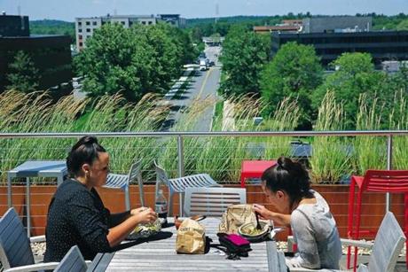 BURLINGTON, MA - 7/18/2018: A rooftop deck has a dining area, grill and outdoor television with a view of the main road below at the office park. Suburban office park...The District Burlington in Burlington is an example of changes that are made to draw workers out of urban areas (David L Ryan/Globe Staff ) SECTION: BUSINESS TOPIC 28coolsuburbs
