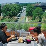 BURLINGTON, MA - 7/18/2018: A rooftop deck has a dining area, grill and outdoor television with a view of the main road below at the office park. Suburban office park...The District Burlington in Burlington is an example of changes that are made to draw workers out of urban areas (David L Ryan/Globe Staff ) SECTION: BUSINESS TOPIC 28coolsuburbs