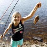 Emma Hiott of Billerica shows off her catch during the MassWildlife Family Fishing Clinic in Billerica, Mass., Wednesday, July 18, 2018. (Winslow Townson for The Boston Globe)