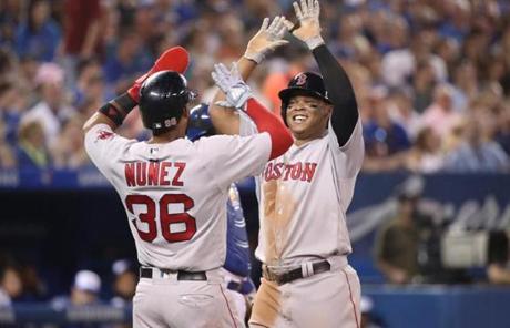 TORONTO, ON - AUGUST 8: Rafael Devers #11 of the Boston Red Sox is congratulated by Eduardo Nunez #36 after hitting a two-run home run in the sixth inning during MLB game action against the Toronto Blue Jays at Rogers Centre on August 8, 2018 in Toronto, Canada. (Photo by Tom Szczerbowski/Getty Images)

