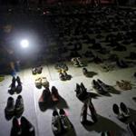 A child shined a light on hundreds of shoes at a memorial in San Juan, Puert Rico, for those killed by Hurricane Maria.