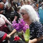 Susan Bro, center, mother of Heather Heyer who was killed during last year's Unite the Right rally, and her husband, Kim, right, speak to supporters after laying flowers at the spot her daughter was killed in Charlottesville, Va., Sunday, Aug. 12, 2018. Bro said there's still 