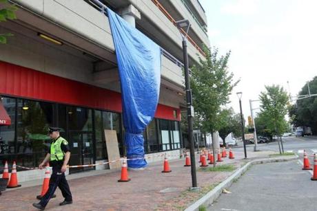 A blue tarp hung in front of the Alewife garage. 
