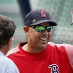 Boston Red Sox manager Alex Cora, center, talks with Tom Werner, left, and Sam Kennedy before a baseball game against the Tampa Bay Rays in Boston, Friday, Aug. 17, 2018. (AP Photo/Michael Dwyer)