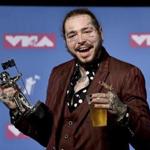 IN this Monday, Aug. 20, 2018 photo, Post Malone poses with the award for song of the year for 
