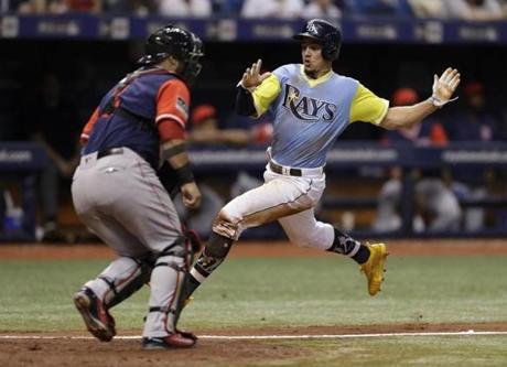 Tampa Bay Rays' Willy Adames, right, scores around Boston Red Sox catcher Sandy Leon on a sacrifice fly by Joey Wendle off relief pitcher Ryan Brasier during the sixth inning of a baseball game Saturday, Aug. 25, 2018, in St. Petersburg, Fla. (AP Photo/Chris O'Meara)
