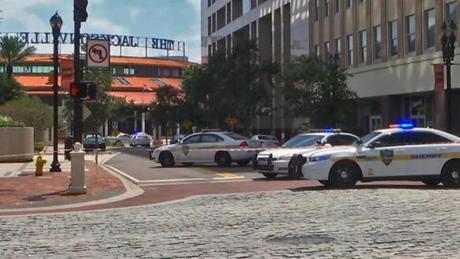 This handout image distributed courtesy of WJXT, a local Jacksonville television station, shows police cars blocking a street leading to the Jacksonville Landing area in downtown Jacksonville, Florida, August 26, 2018. - Several people have been killed in a mass shooting at a video game tournament in the northern Florida city of Jacksonville, local police said Sunday, August 26, 2018, adding that one suspect was dead. (Photo by HO / Courtesy of WJXT / AFP) / == RESTRICTED TO EDITORIAL USE / MANDATORY CREDIT: 